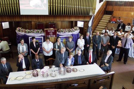 Die bediening van die Heilige Nagmaal deur ds Dirk van Dyk (middel) met al 7 streeksverteenwoordigers by die Nagmaalstafel